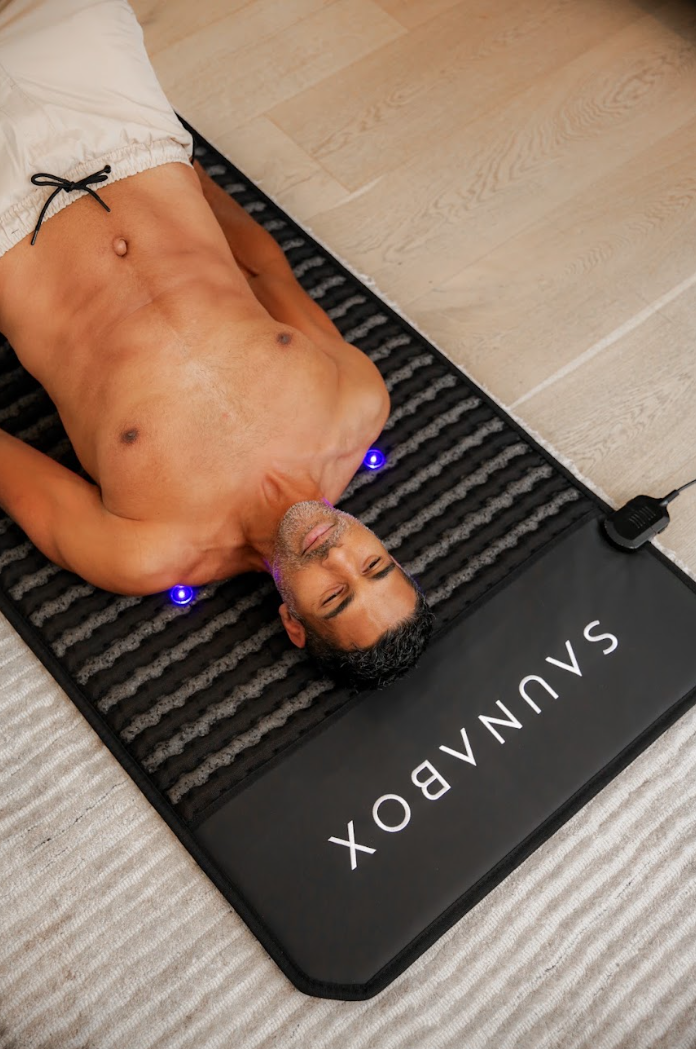 Person lying on SaunaBox PEMF Mat during therapy session